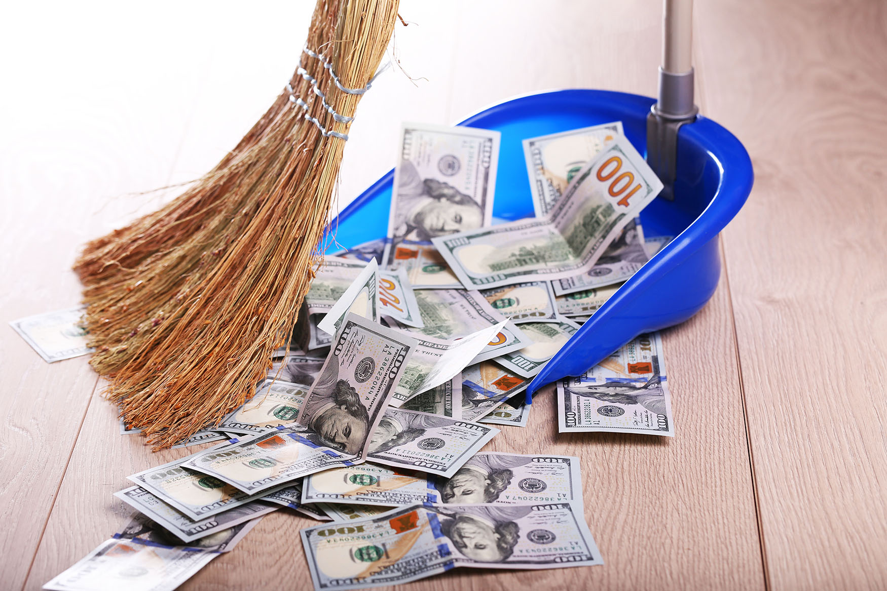 Broom sweeping up money
